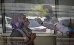 A health worker takes a swab sample to test for COVID-19 at