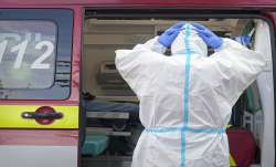 A paramedic adjusts his protection equipment outside the