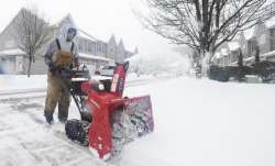 Joe Miscavage uses a snow blower to clear a driveway at
