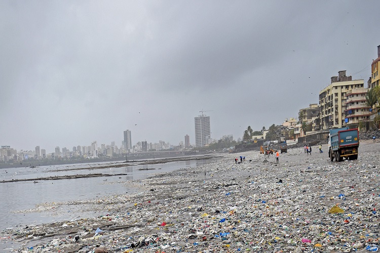 Brihanmumbai Municipal Corporation (BMC) workers clear the garbage washed ashore after a high tide on Mahim beach, in Mumbai on Saturday.
 
 