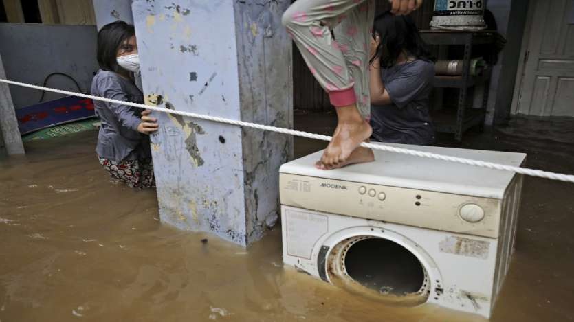 A girl looks on as she stands in the water at a flooded neighborhood following heavy rains in Jakarta, Indonesia.