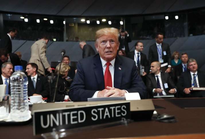 US President Donald Trump takes his seat as he attends the