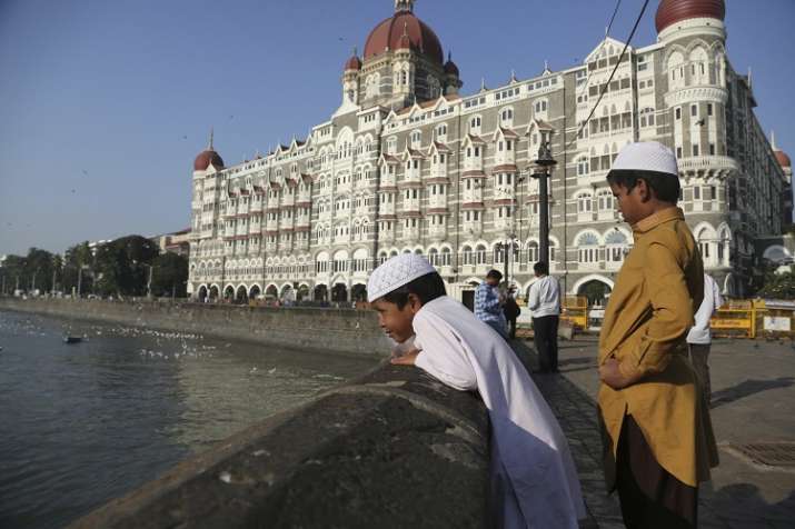 Two boys stand outside the iconic Taj Mahal Palace hotel,