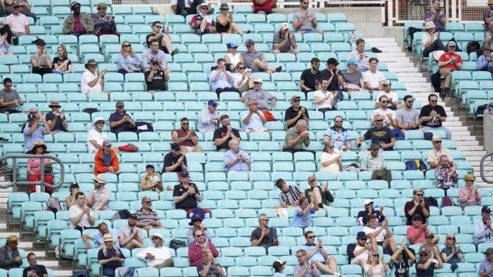 Spectators observe social distancing in the stands during