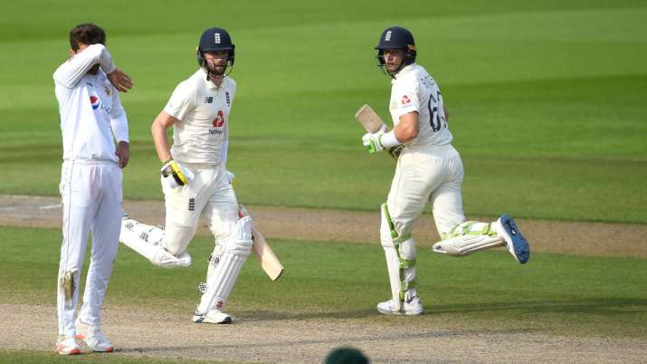 Jos Buttler and Chris Woakes of England run watched on by