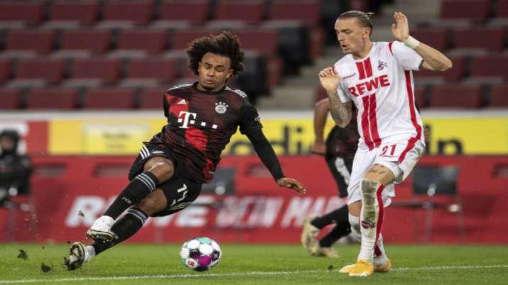 Bavaria's Joshua Zirkzee, left, stumbles next to Cologne's