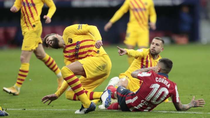 Barcelona's Gerard Pique, left, reacts after getting an