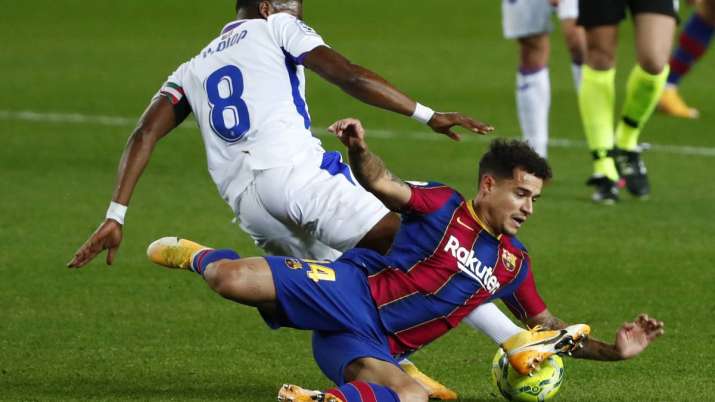 Eibar's Pape Diop, left, challenges Barcelona's Philippe
