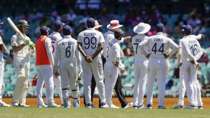 Australia's Tim Paine, left, waits as Indian players talk