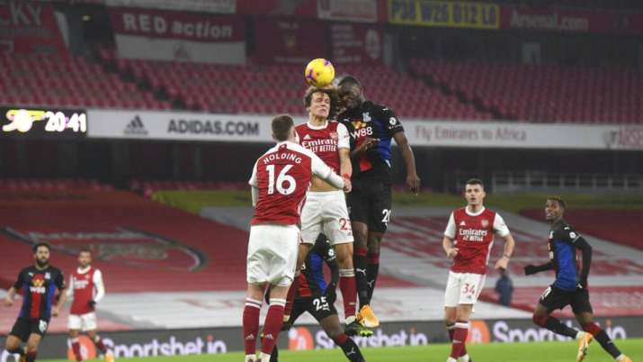 Arsenal's David Luiz, center, jumps for the ball with