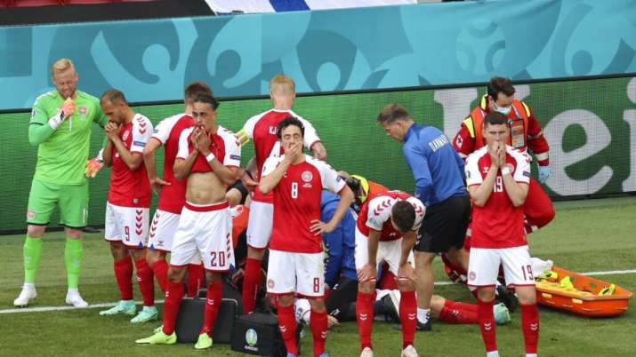 Denmark players react while medics assist their teammate Christian Eriksen