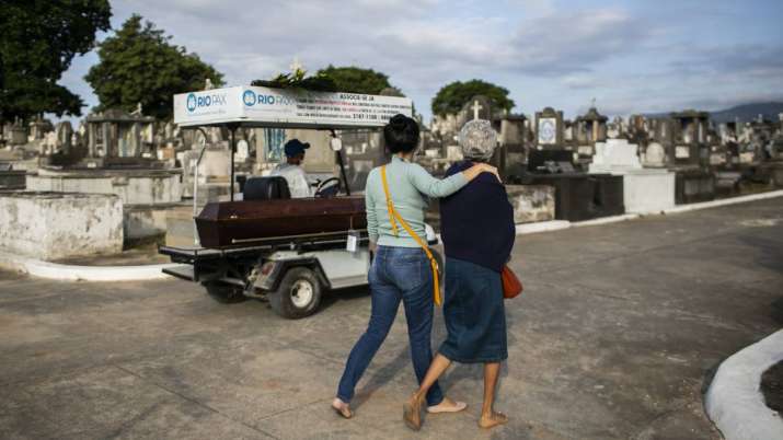 Relatives accompany the coffin that contains the remains of