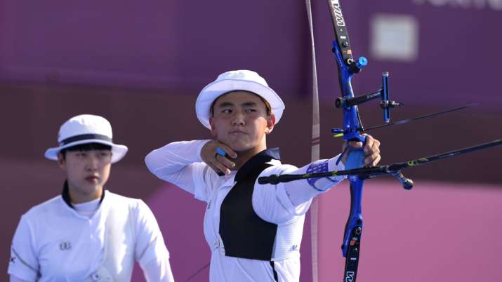 South Korea's Kim Je Deok releases an arrow flanked by his