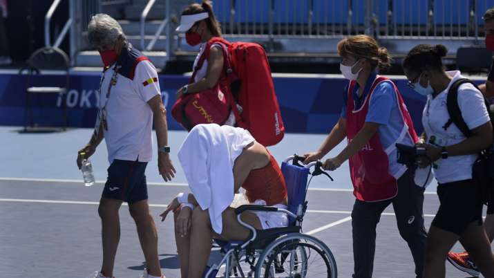 Paula Badosa, of Spain, is helped off the court in a