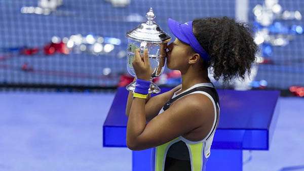 Naomi Osaka, of Japan, holds up the championship trophy