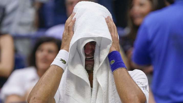 Novak Djokovic, of Serbia, cries as he sits on his bench
