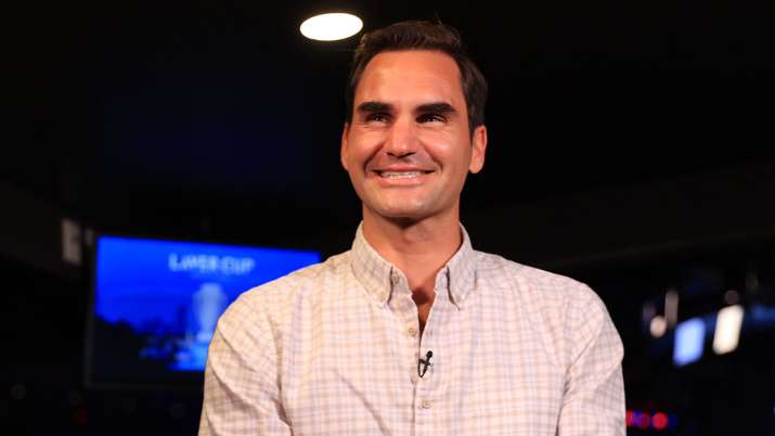 Roger Federer reacts during an interview with Andy Roddick
