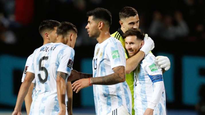 Argentina's goalkeeper Emiliano Martinez, second right, embraces teammate Lionel Messi at the end of