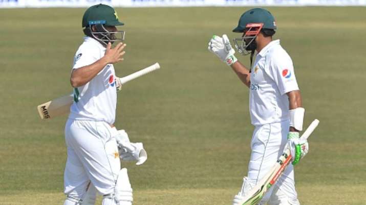 Pakistan's captain Babar Azam (left) celebrates with teammate Azhar Ali after winning the 1st Test a