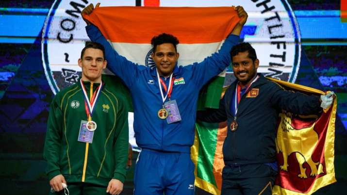 Indian weightlifter Ajay Singh (center) on stage at Commonwealth Weightlifting Championships