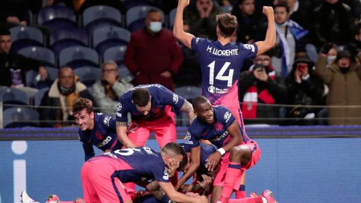 Atletico Madrid's Angel Correa, (on the ground) is crowded by teammates in jubilation after the forw