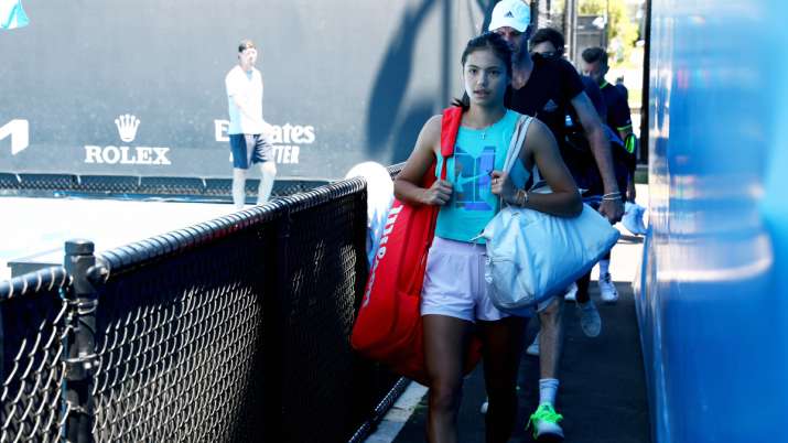 Emma Raducanu walks to her practice court with her coach Torben Beltz prior to a practice session at
